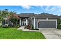 Charming gray home with a well-manicured lawn, beautiful landscaping, and an inviting entrance at 4825 Waterwitch Point Dr, Orlando, FL 32806
