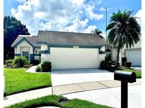 Charming single-story home showcasing a two-car garage, well-manicured lawn, and lush landscaping at 5804 Plum Pudding Ct, Orlando, FL 32821
