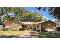 Charming single-story home featuring stone accents, mature landscaping, and an attached two-car garage at 8547 Cedar Cove Dr, Orlando, FL 32819