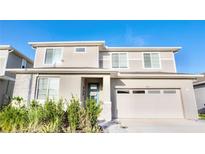 Charming two-story home featuring a two-car garage, well-manicured landscaping, and a welcoming front entrance at 1023 Sugarwood St, Davenport, FL 33837