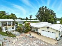 Waterfront home with a detached garage and covered parking area with mature landscaping and view of lake at 130 Masterpiece Rd, Lake Wales, FL 33898