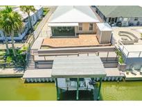 A waterfront home with a large deck, brick patio, boat dock, and boat lift is seen from an aerial view at 139 Douglas St, Edgewater, FL 32141
