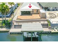 Waterfront home featuring a patio, screened-in porch, and dock with boat lift at 139 Douglas St, Edgewater, FL 32141