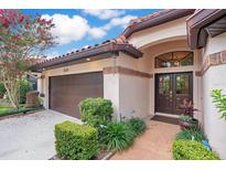 Welcoming front entrance featuring a brick walkway, a dark double door, and a well-manicured garden at 1609 Glen Eagles Way, Orlando, FL 32804