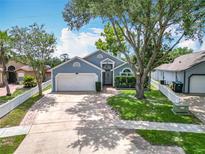 Charming home featuring a well-manicured lawn, a brick-lined driveway, and mature trees at 2641 Delcrest Dr, Orlando, FL 32817