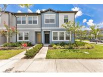 Charming townhome featuring blue and gray exterior, manicured lawn, and inviting curb appeal at 3303 Azolla St, Orlando, FL 32808