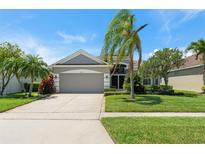 Well-maintained single-Gathering home with a lush lawn, mature trees, and a two-car garage at 3419 Fernwood Dr, Kissimmee, FL 34741