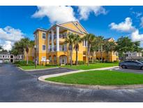 Beautiful multi-story yellow apartment building with palm trees and well-manicured landscaping at 3707 Conroy Rd # 1715, Orlando, FL 32839