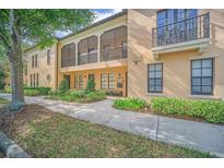 Attractive two-story condo exterior with manicured landscaping, walkway, porch and balcony at 506 Mirasol Cir # 202, Celebration, FL 34747