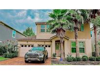 Stunning two-story home with a brick driveway, lush landscaping, and mature palm trees, giving it great curb appeal at 5169 Dove Tree, Orlando, FL 32811
