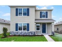 Charming two-story home featuring blue shutters, stone accents, and a well-manicured lawn at 5242 Scrub Mint Ln, Apopka, FL 32712