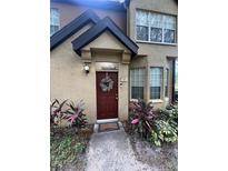 Inviting front entrance with a decorative wreath on the red door and well-maintained landscaping at 6328 Raleigh St # 814, Orlando, FL 32835
