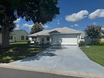 Charming single-story home featuring a well-maintained lawn and a spacious two-car garage at 732 Palma Dr, Lady Lake, FL 32159