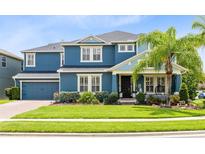 Charming two-story home boasts a manicured lawn, blue exterior, and inviting front porch at 11850 Sheltering Pine Dr, Orlando, FL 32836