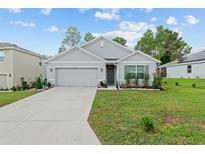 Charming single-story home with landscaped front yard and a two-car garage at 133 Hickory Course Circle, Ocala, FL 34472