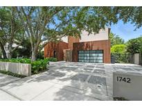 Stunning modern home with unique exterior, featuring a decorative driveway and mature landscaping at 1742 Temple Dr, Winter Park, FL 32789
