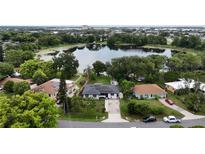 Beautiful aerial view of home with solar panels, pond, and lush landscaping at 2154 Lake Christie Dr, Orlando, FL 32809