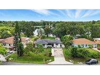 Charming single-story home features solar panels, a long driveway, and lovely landscaping with a lake view at 2154 Lake Christie Dr, Orlando, FL 32809