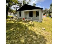 Exterior of home featuring neutral paint with black trim, complemented by a lush, green lawn at 2352 Ross St, Kissimmee, FL 34744