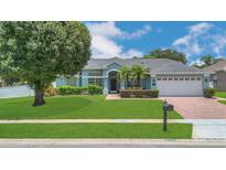 Charming single-story home with a well-manicured lawn, mature trees, and a brick driveway at 2674 Sugar Pine Run, Oviedo, FL 32765