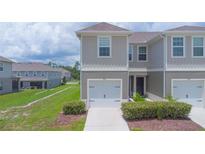 Attractive townhome featuring a one-car garage and manicured landscaping at 275 Blueberry Ln, Davenport, FL 33837
