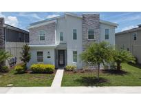 Charming two-story home featuring modern design with stone accents and well-manicured landscaping at 2855 Bookmark Dr, Kissimmee, FL 34746