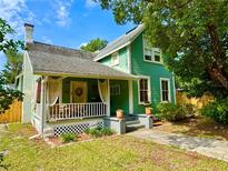 Charming green two-story home with a cozy front porch and well-maintained landscaping at 311 W 10Th St, Sanford, FL 32771
