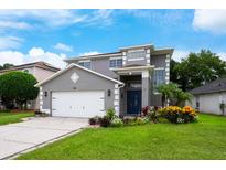 Charming two-story home with a manicured lawn and a freshly painted gray exterior at 415 Eastbridge Dr, Oviedo, FL 32765