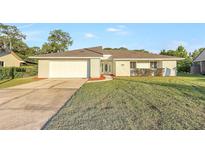 Charming single-story home featuring a well-manicured lawn, driveway, attached garage, and inviting front entrance at 520 Eagle Cir, Casselberry, FL 32707