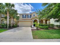 Inviting two-story home featuring a tile roof, manicured lawn, and an attached two-car garage at 5368 Oakbourne Ave, Davenport, FL 33837