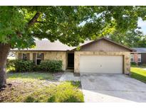 Charming single-story home with a stone facade, two-car garage, and mature tree in the front yard at 6835 Massa Ct, Orlando, FL 32810
