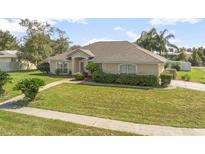 Charming single-story home with a well-manicured lawn and mature landscaping at 710 Independence Dr, Orange City, FL 32763