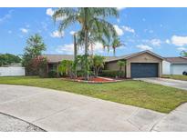Charming single-story home with well-manicured front lawn, mature landscaping, and a two-car garage at 1090 Sonoma Ct, Longwood, FL 32750