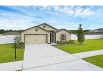 Charming single-story home with a well-manicured lawn and two car garage at 12835 Del Lago Dr, Astatula, FL 34705