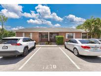 Charming brick duplex features a well-maintained facade with dedicated parking spaces for residents and guests at 1288 Americana Pl, Orlando, FL 32807