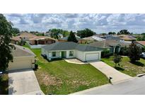Charming single-story home with well-manicured lawn, attached garage, and freshly painted exterior at 130 Winsor Ave, Davenport, FL 33837