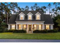 Charming two-story home featuring a welcoming front porch, manicured lawn, and well-maintained landscaping at 1443 Stone Trl, Enterprise, FL 32725