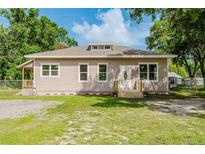 Inviting single-story home with charming curb appeal, lush lawn, and mature shade trees at 1480 Wauchula St, Intercession City, FL 33848