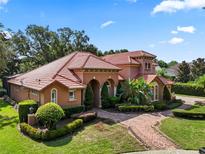 Stunning home with a red tile roof, lush landscaping, and a brick paver walkway at 1813 Glenbay Ct, Windermere, FL 34786