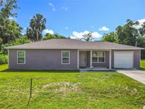 Charming single-story home featuring a well-maintained lawn and a one car garage, with mature trees in the background at 1816 Alexander Ave, Sanford, FL 32771