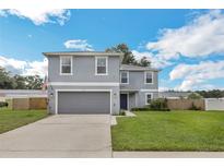 Charming two-story home featuring a manicured lawn, two car garage and lovely curb appeal at 2032 Wavyleaf Ct, Apopka, FL 32712