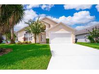 Charming single Gathering home with a well maintained lawn, bright driveway, and lovely blue sky at 207 Langham Dr, Davenport, FL 33897