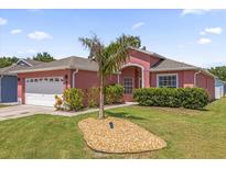 Charming pink single-story home with a two-car garage and well-maintained front yard at 2513 Hickory Oak Blvd, Orlando, FL 32817