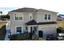 Two story home featuring an attached garage, manicured shrubbery, and neutral stucco exterior at 376 Willet Street Willet St, Haines City, FL 33844