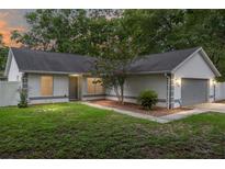 Charming single-story home with well-maintained lawn, gray accents and a cozy, inviting entrance at 5430 Nw 55Th Pl, Ocala, FL 34482