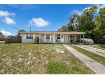 Charming single-story home featuring a welcoming front porch and covered parking at 565 S Floyd Cir, Deltona, FL 32725
