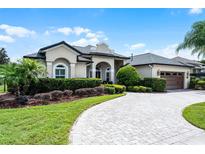 Well-maintained home with manicured lawn, paver driveway, and lush landscaping at 5740 Aloma Woods Blvd, Oviedo, FL 32765