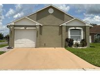 Charming single-story home with a light tan stucco exterior and well-maintained front yard at 7601 Fort Sumter Dr, Orlando, FL 32822