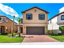 Charming two-story home featuring a brick driveway, neutral exterior, and well-maintained landscaping at 1512 Mumbai Way, Kissimmee, FL 34747