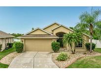 Charming single-story home with a well-manicured lawn and inviting curb appeal with tropical landscaping at 2360 Brewerton Ln, Orlando, FL 32824